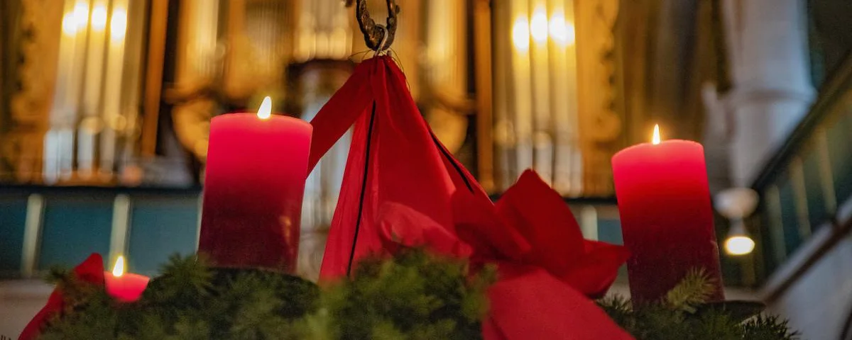 Ein Adventskranz mit brennenden Kerzen.